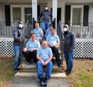 Group Home Members Sitting On Steps Smiling