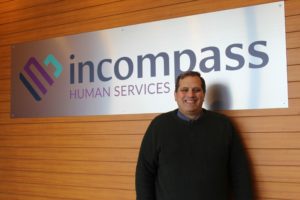Shawn Nault In Front Of Incompass Logo