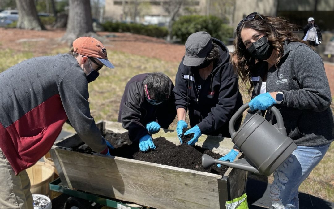 Group Of People Planting Outdoors With Masks On for Earth Day