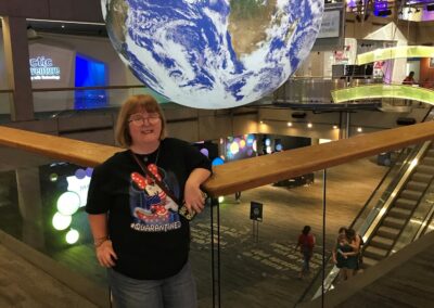 Woman Overlooking A globe and Escalator